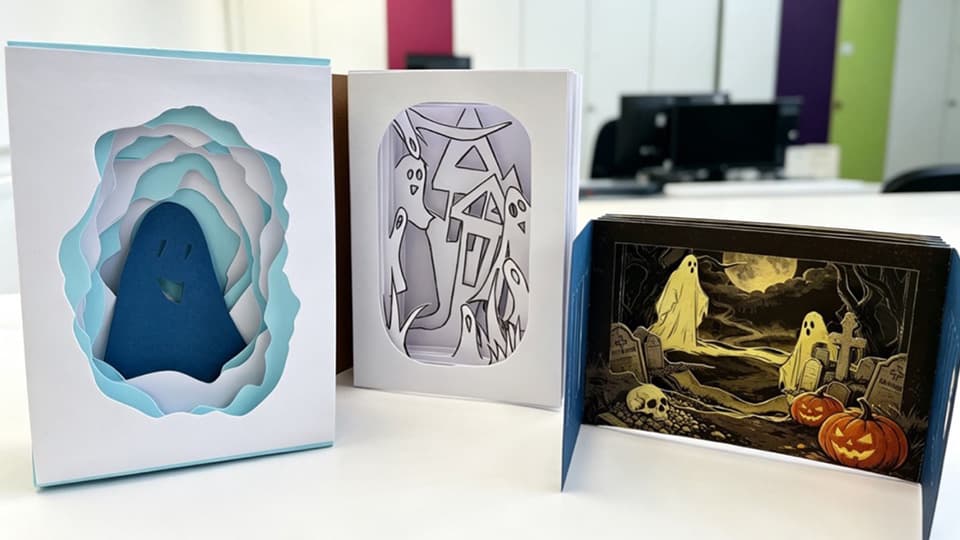Several small books with 3 dimensional halloween designs, made using layers of paper.